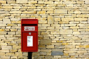 Royal mail post box in front of a brick wall